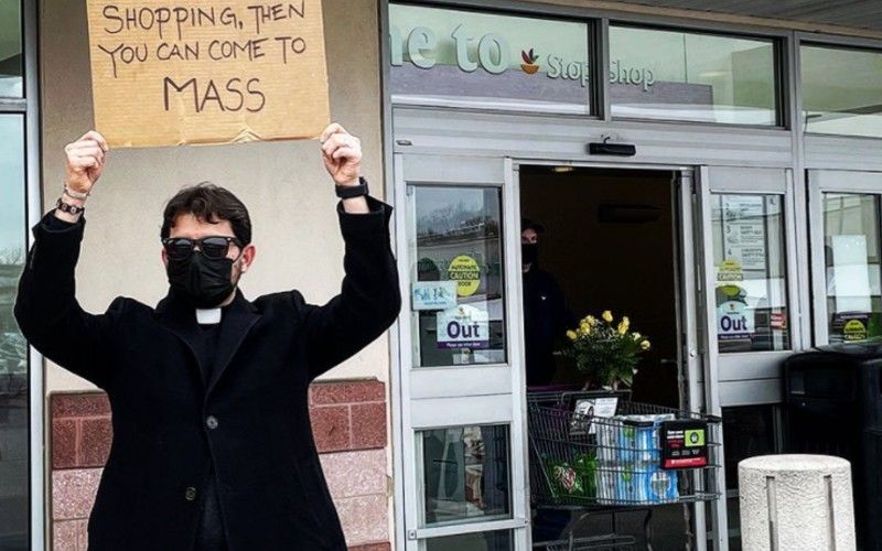 NY Priest Stands Outside Grocery Store With Sign Encouraging Catholic Mass Attendance